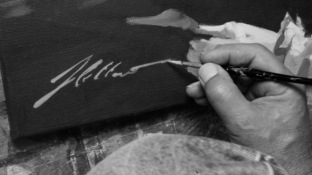 Der Pferdemaler Hartmut Hellner signiert ein vollendetes Gemälde.